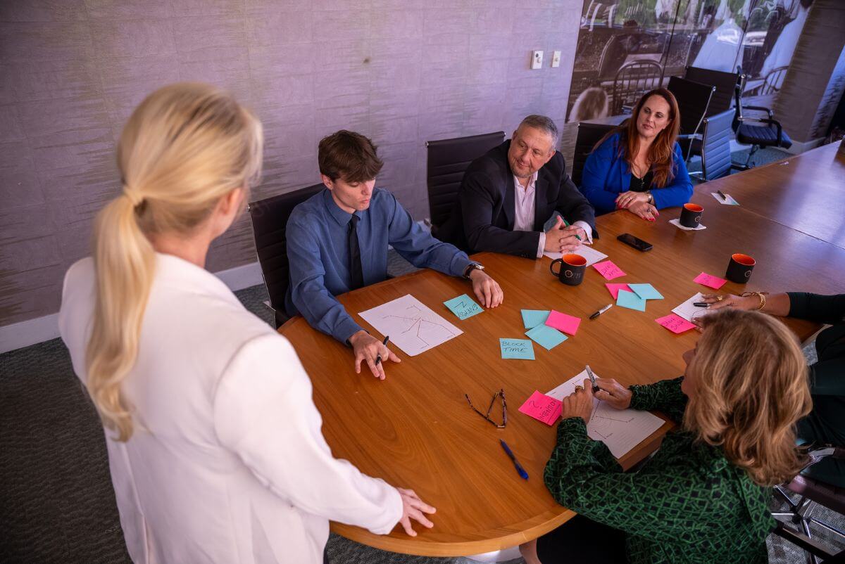 live event - Kim speaking to group around a table